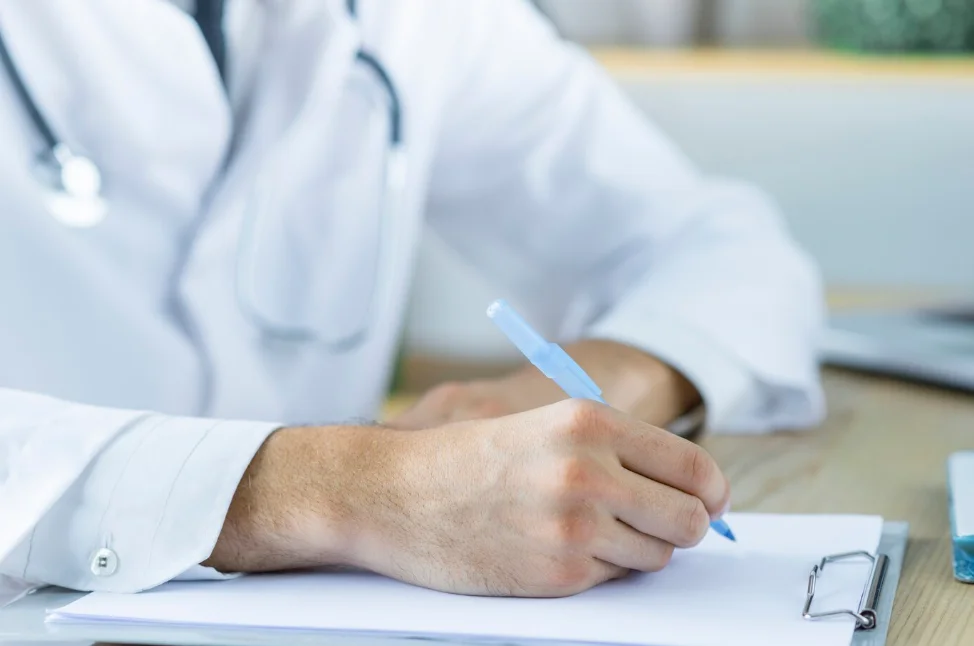 médico fazendo anotações sobre prova de revalidação em medicina