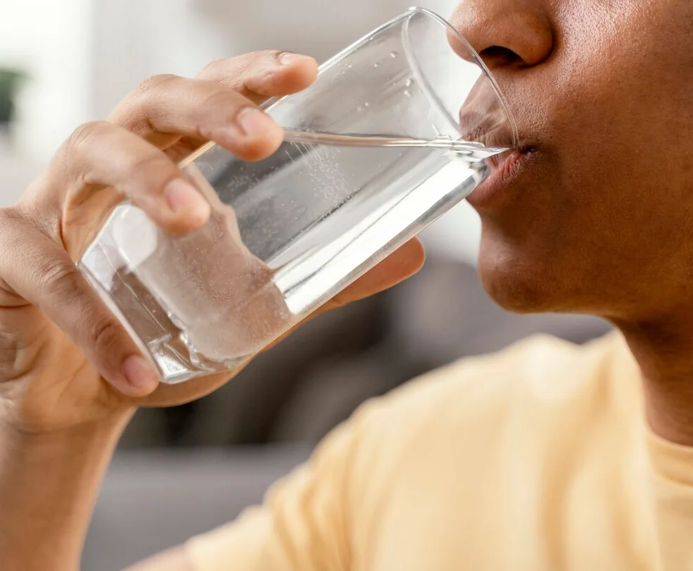 jovem-de-camisa-amarela-bebendo-agua